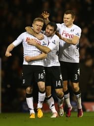 Damien Duff of Fulham (L) celebrates with team mates Giorgos Karagounis and John Arne Riise after his assist in Hugo Rodallega's goal